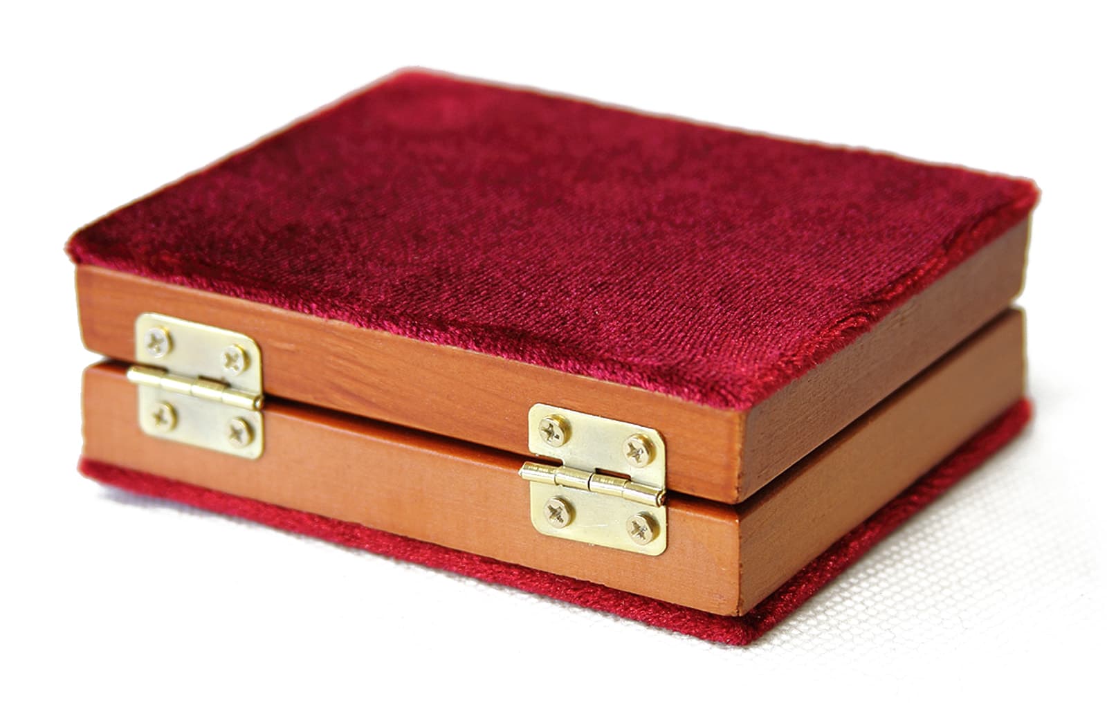 The folding diptych closed in its red velvet cover, hinge side