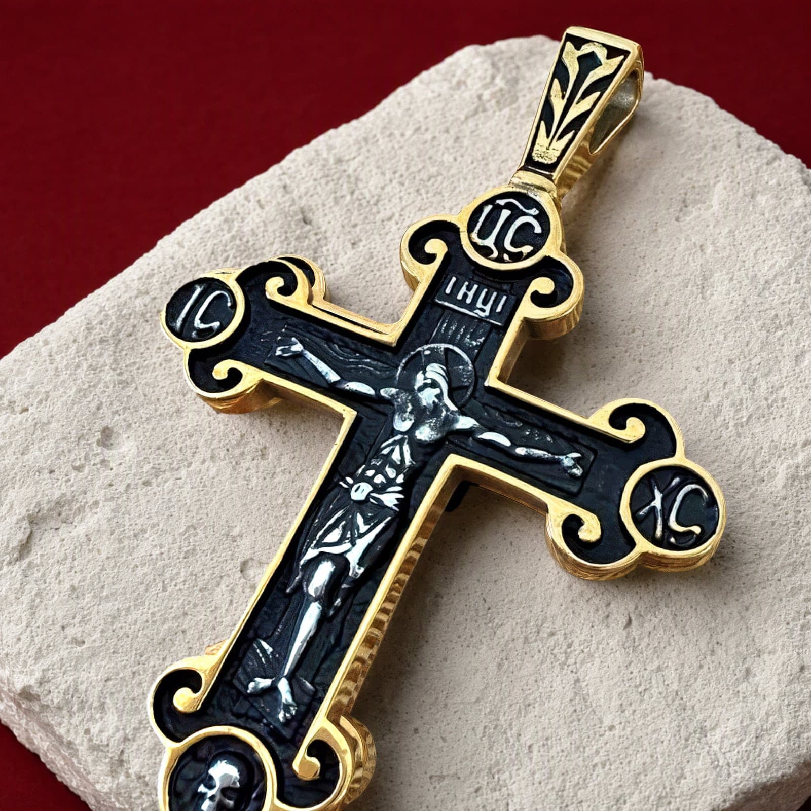 Close-up of the Orthodox Crucifix (Roundels) - Black&Gold Color - Stainless Steel Cross: the relief and the bail in raking light.