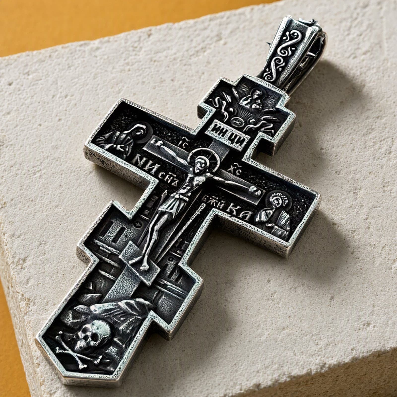 Close-up of the Orthodox Crucifix (Mary and St John, Dark) - Silver Color - 60cm Chain - Stainless Steel Cross: the relief and the bail in raking light.