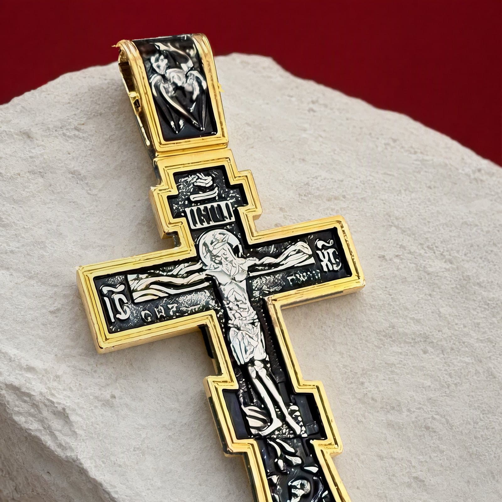 Close-up of the Orthodox Crucifix - Black&Gold Color - 60cm Chain - Stainless Cross: the relief and the bail in raking light.