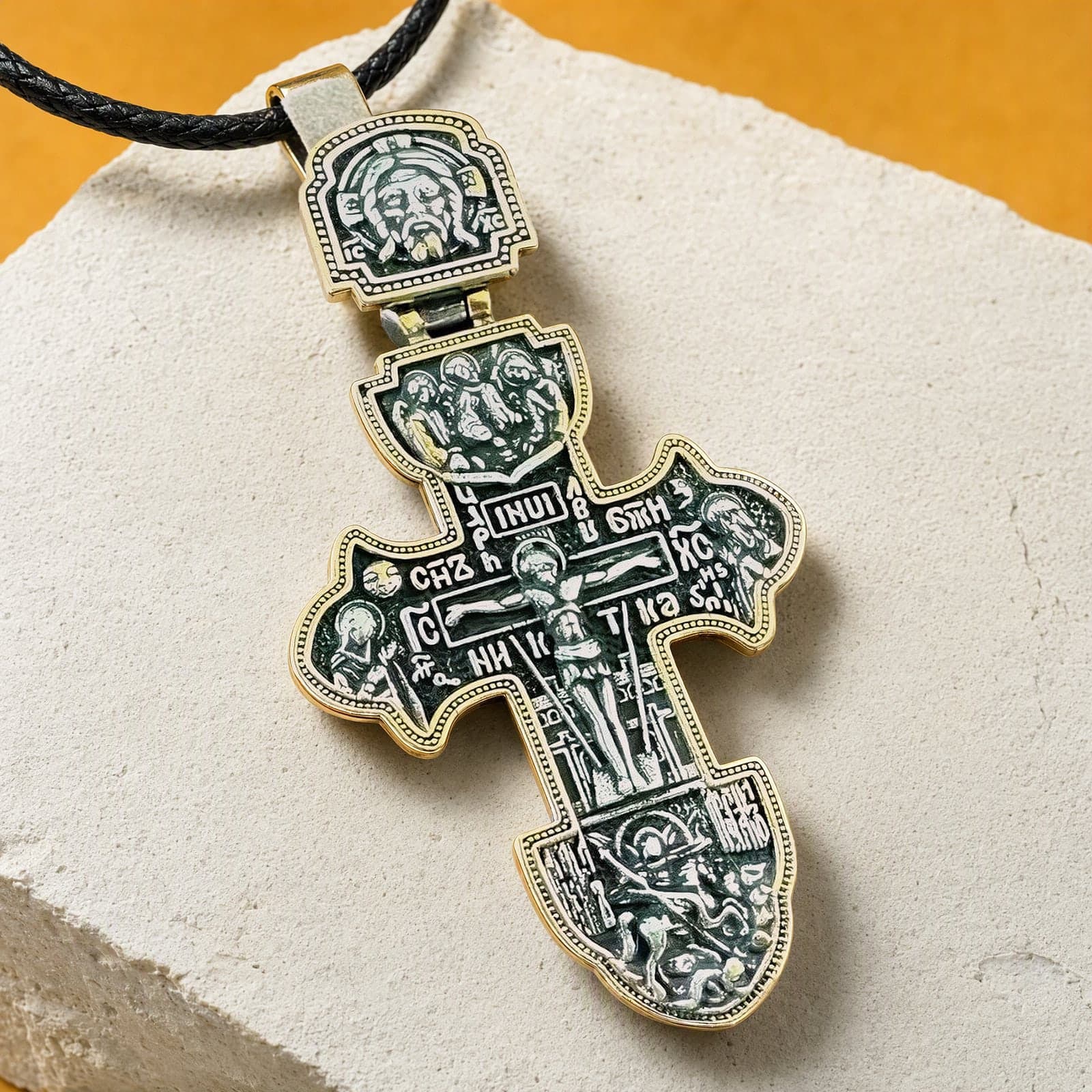 Close-up of the Orthodox Crucifix (Ornate) - Black&Gold Color - Stainless Steel Cross: the relief and the bail in raking light.