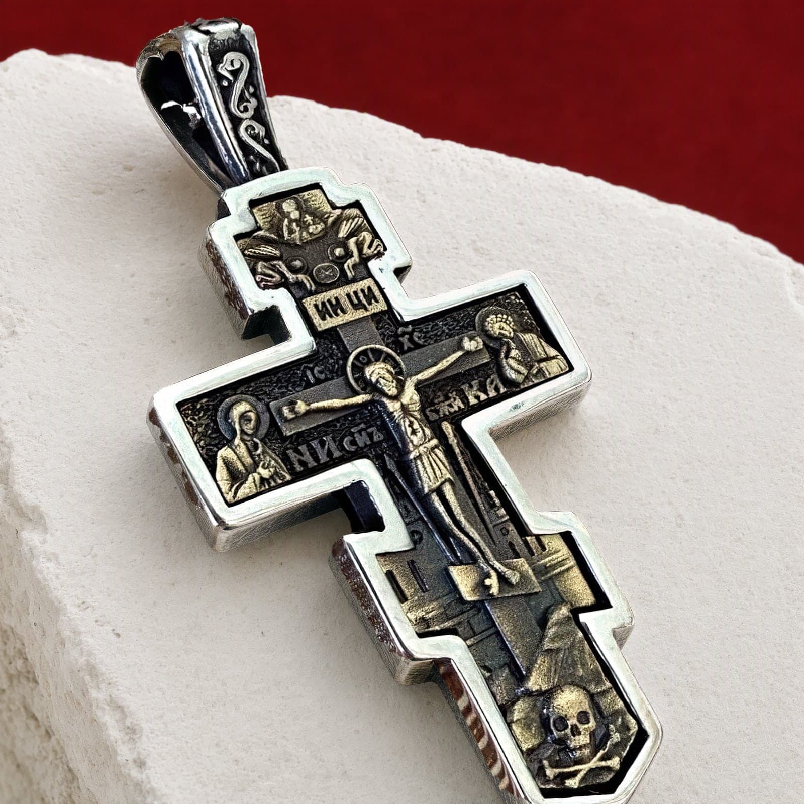 Close-up of the Orthodox Crucifix (Mary and St John, Two-Tone) - Silver Color - 60cm Chain - Stainless Steel Cross: the relief and the bail in raking light.