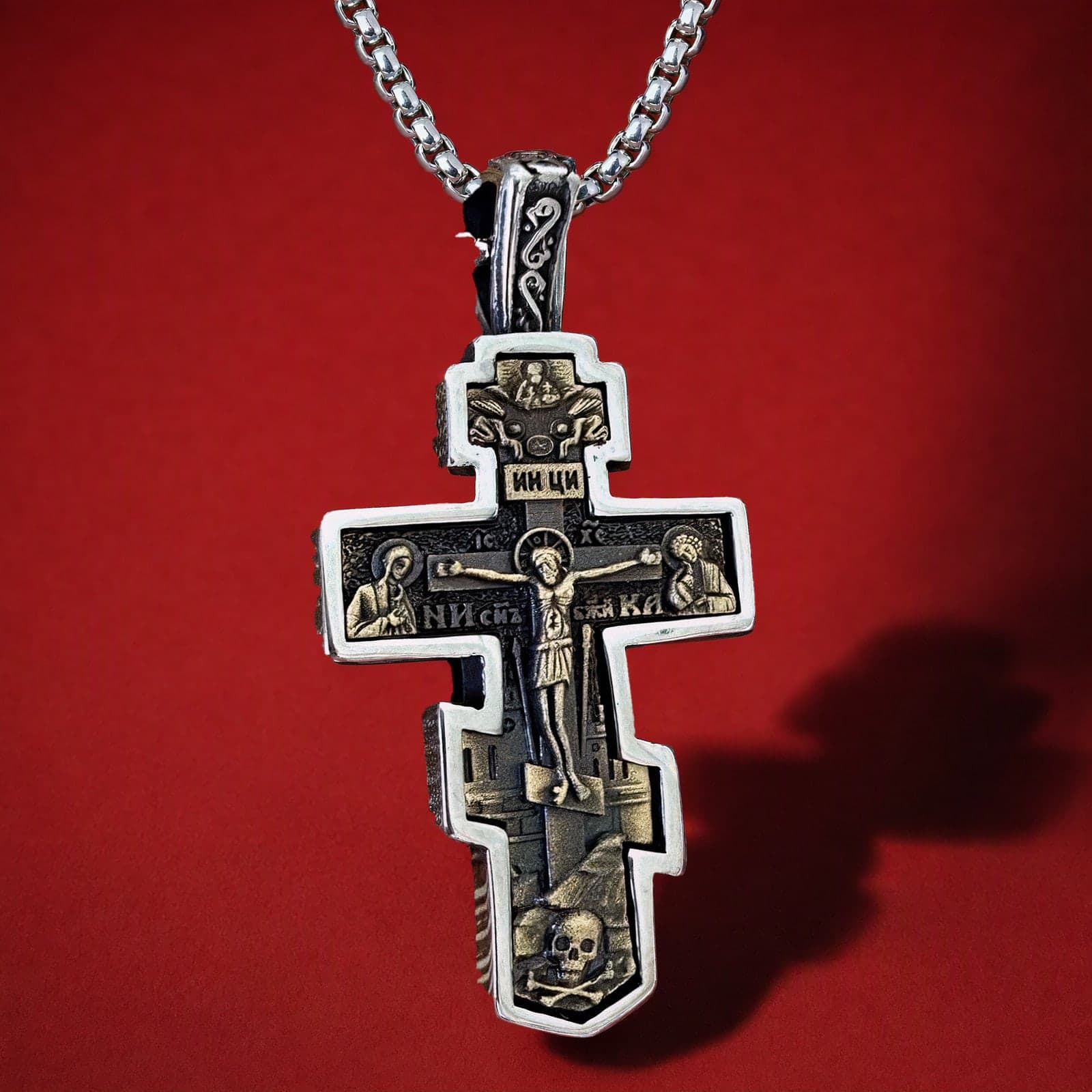 Orthodox Crucifix (Mary and St John, Two-Tone) - Silver Color - 60cm Chain - Stainless Steel Cross: an antiqued silver-tone stepped Orthodox crucifix with an ornamented bail on a silver-tone box chain, against an oxblood backdrop.