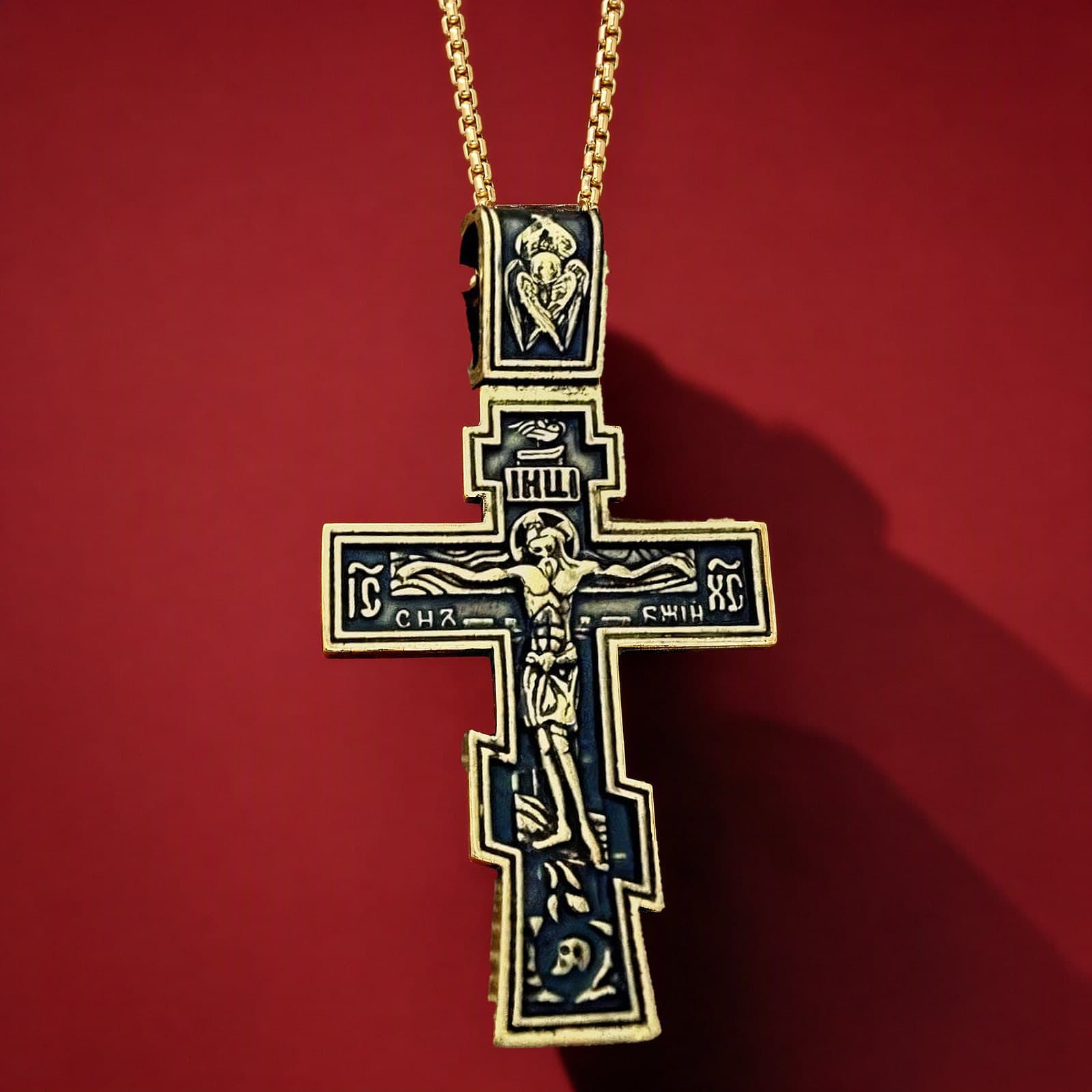 Orthodox Crucifix (Son of God) - Black&Gold Color - 60cm Chain - Stainless Steel Cross: a black-and-gold stepped Orthodox crucifix: gold-tone rim and angel bail, blackened field with relief of the Crucifixion on a gold-tone box chain, against an oxblood backdrop.