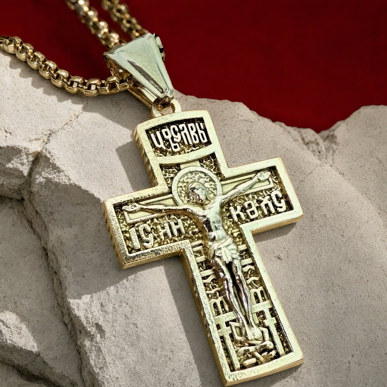 Close-up of the Orthodox Crucifix (King of Glory) - Gold Color - Stainless Steel Cross: the relief and the bail in raking light.
