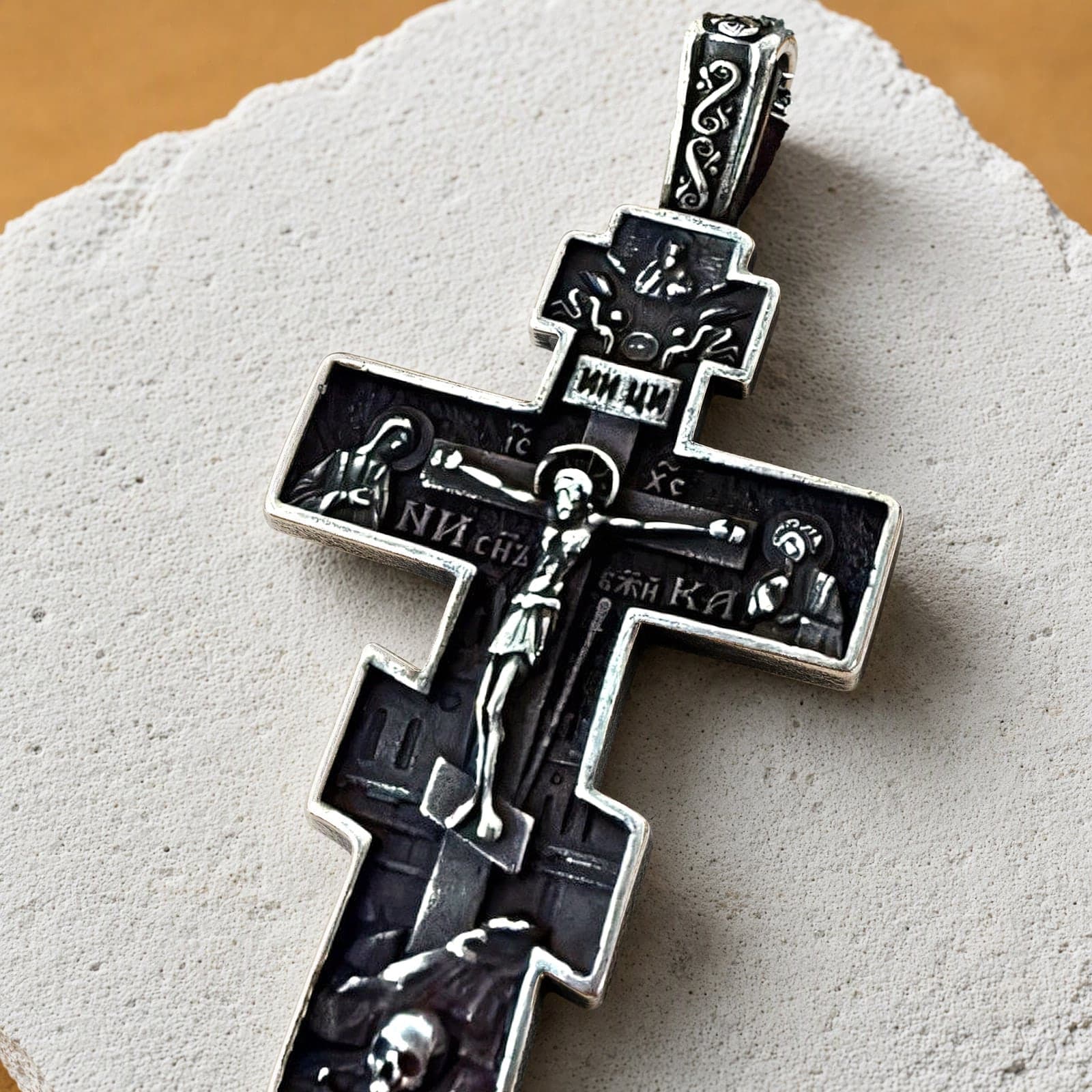 Close-up of the Orthodox Crucifix - Black&Silver Color - 60cm Chain - Stainless Steel Cross: the relief and the bail in raking light.