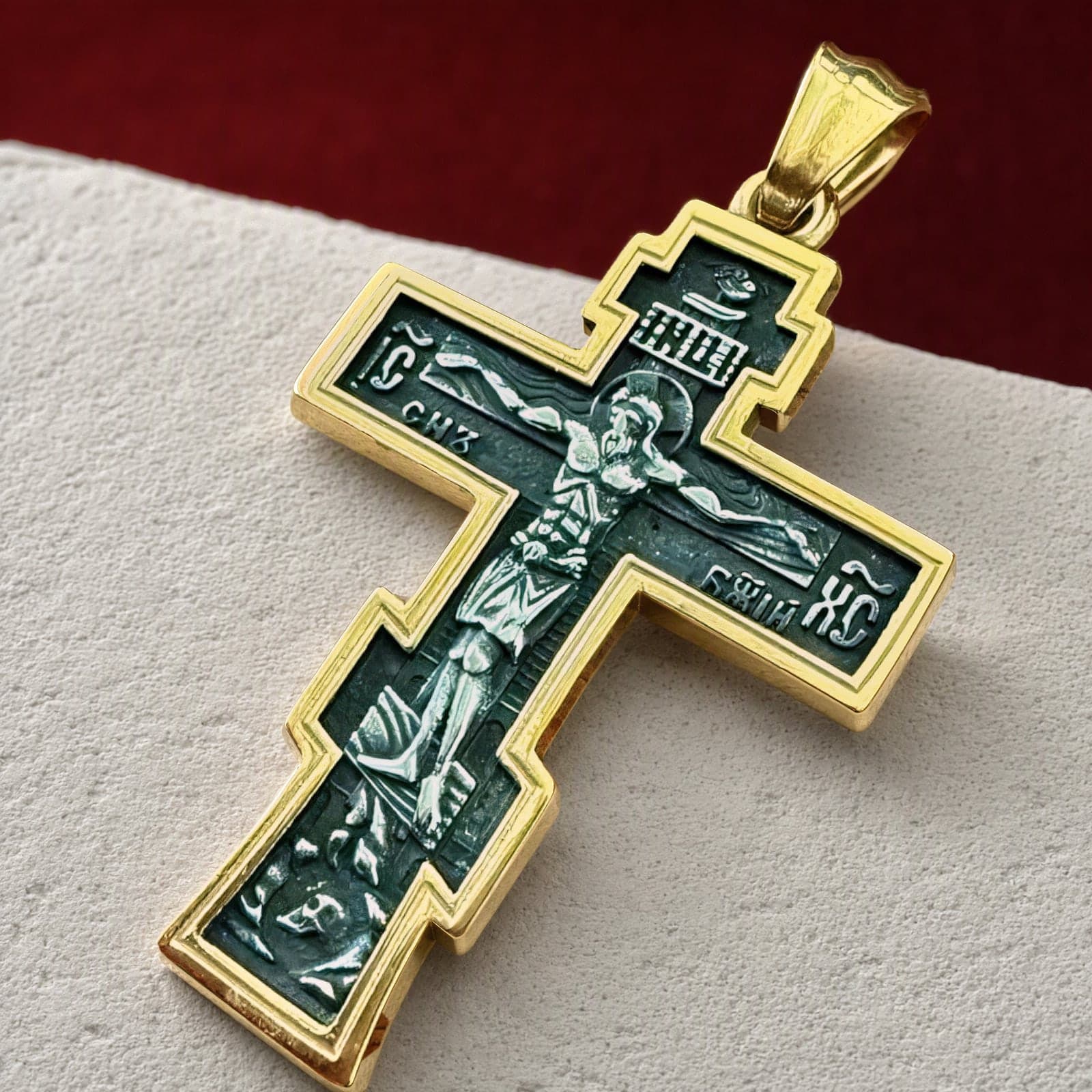 Close-up of the Orthodox Crucifix (Son of God) - Black&Gold Color - Stainless Steel Cross 70x39mm 20.2g: the relief and the bail in raking light.