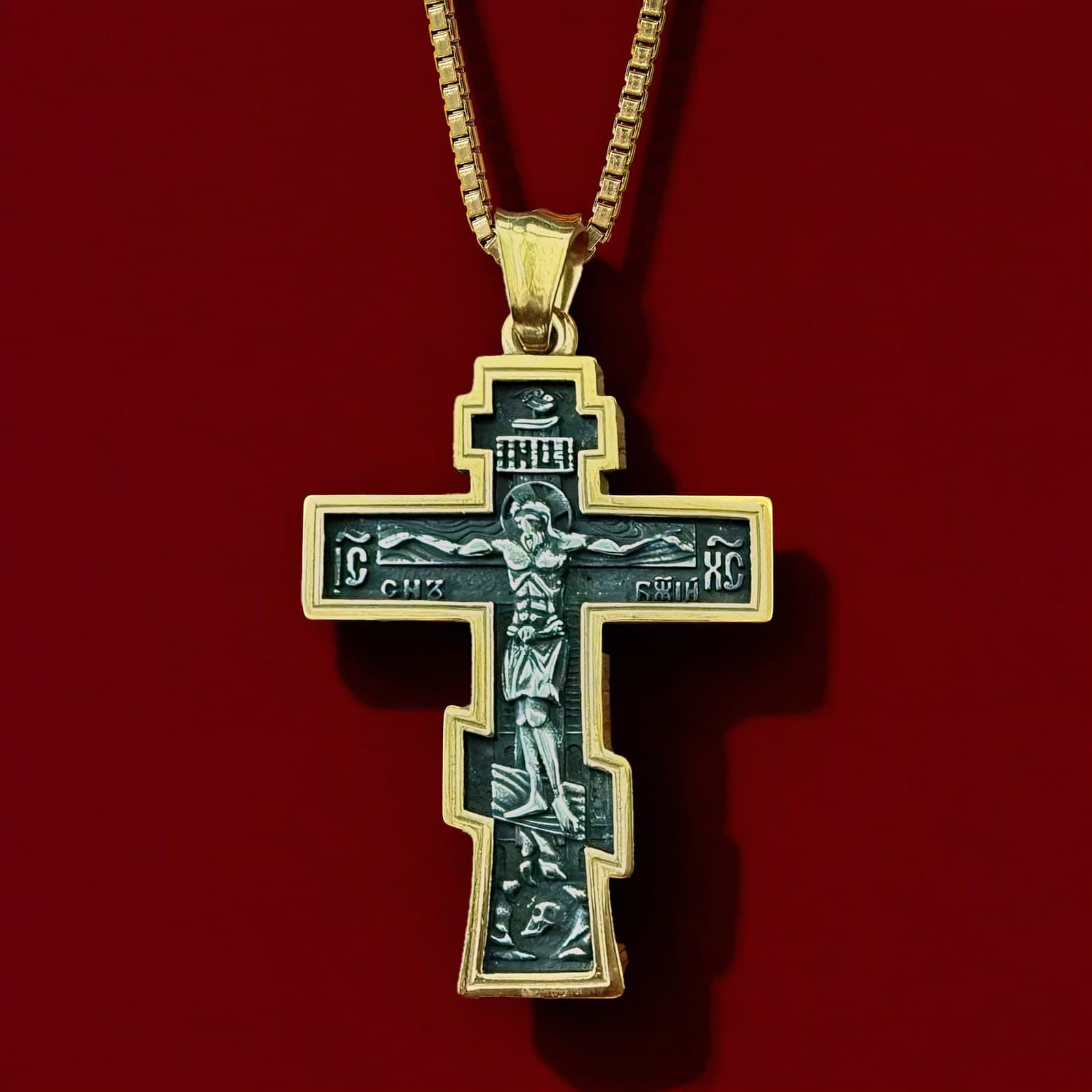 Orthodox Crucifix (Son of God) - Black&Gold Color - Stainless Steel Cross 70x39mm 20.2g: a black-and-gold stepped Orthodox crucifix: polished gold-tone rim, blackened field with silver relief of the Crucifixion on a plain gold-tone box chain (shown on a chain), against an oxblood backdrop.