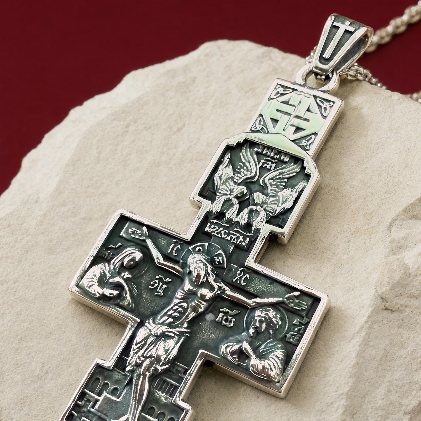 Close-up of the Orthodox Crucifix (Angels) - Silver Color - Stainless Steel Cross 70x39mm 20.2g: the relief and the bail in raking light.