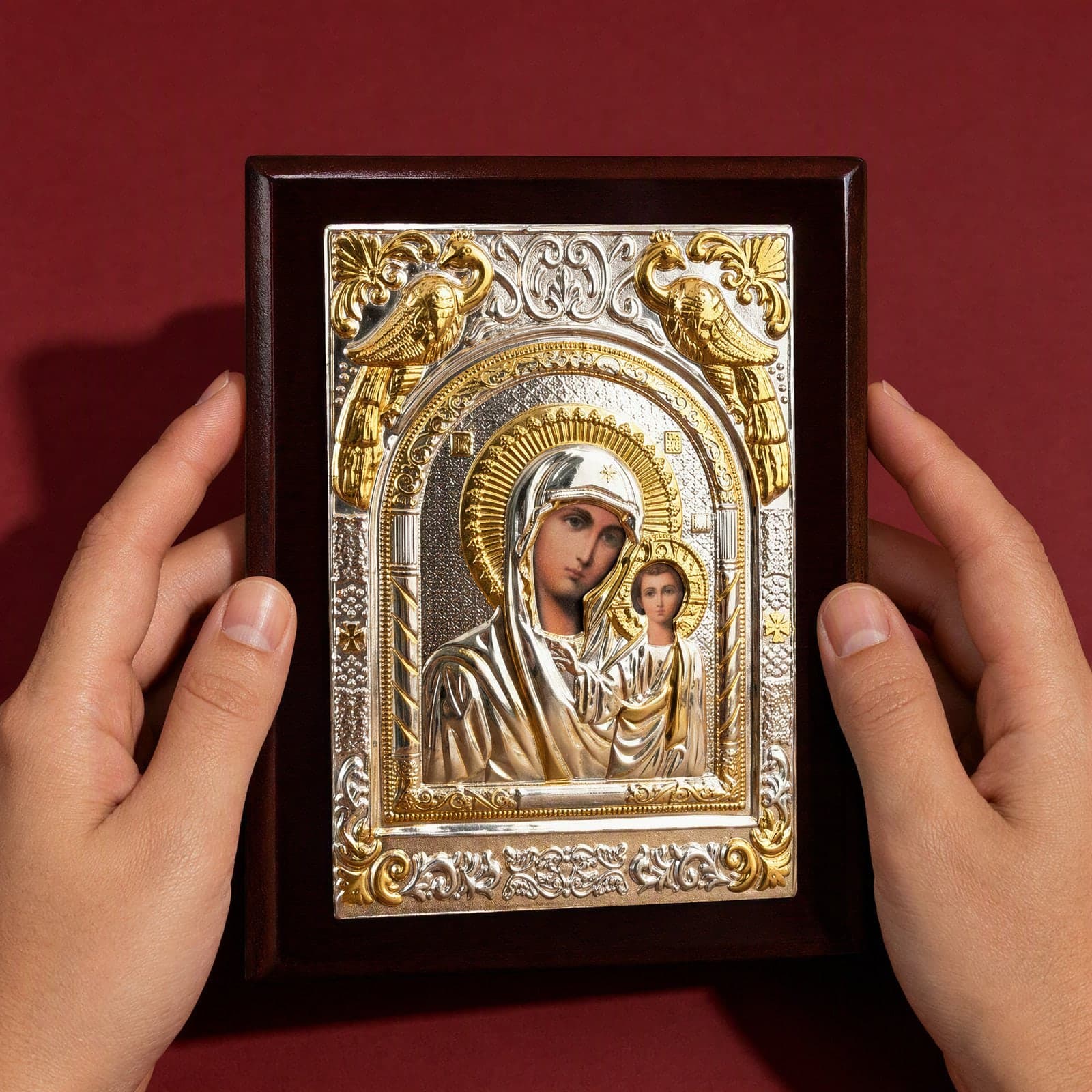 Orthodox Virgin Mary (Our Lady of Kazan, Rectangular), silver and gold wooden icon held in both hands at its true size (14 x 11 cm).