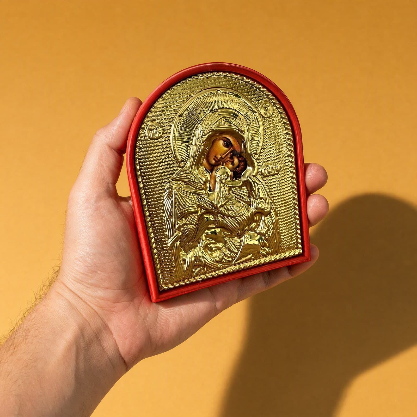 Orthodox Mother of God - Gold Color - Wooden Icon held in one hand to show its size (about 14 x 11 cm).