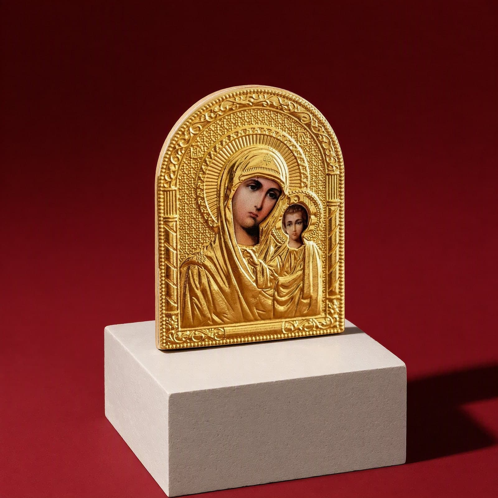 Orthodox Virgin Mary Holding Jesus - Gold Color - Icon seen from a 45-degree angle on a white plinth.