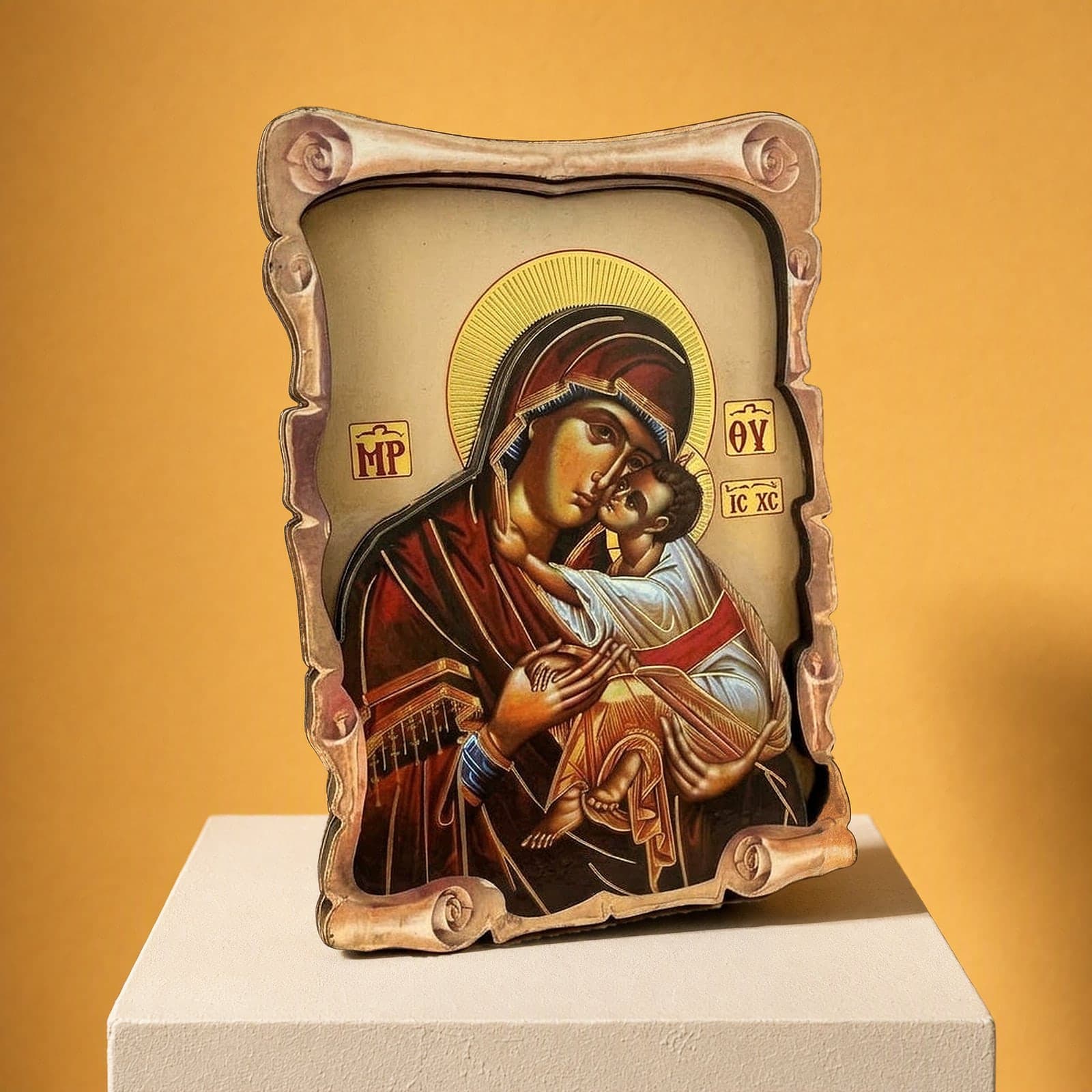 Orthodox Mother of God & Christ - Wooden Icon 14х9cm: a printed icon of the Mother of God with the Christ Child on a shaped wooden board with a scalloped edge, on a white plinth against an ochre backdrop.