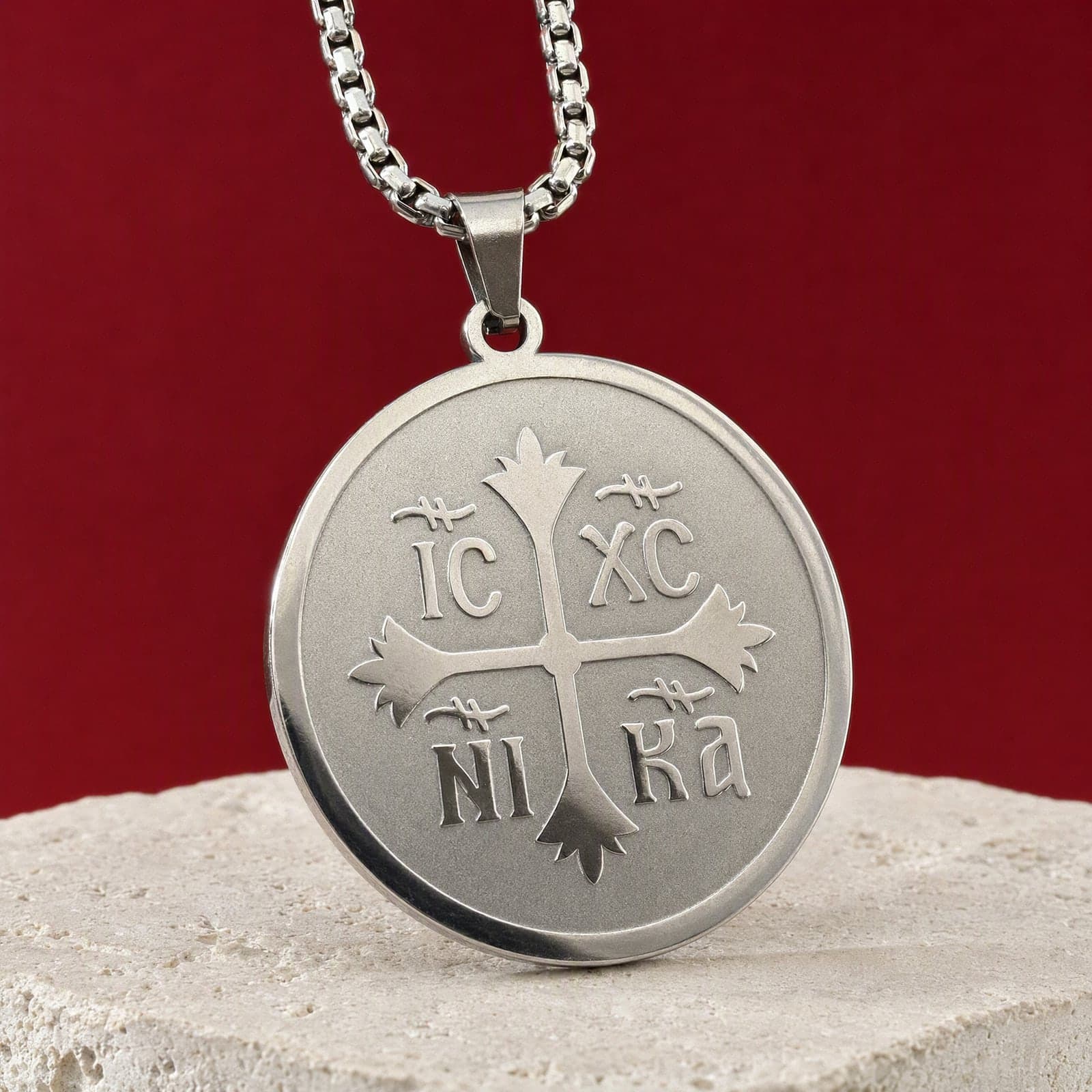 Orthodox IC XC NIKA, silver-tone stainless steel medallion: close-up of the front relief, on its chain.