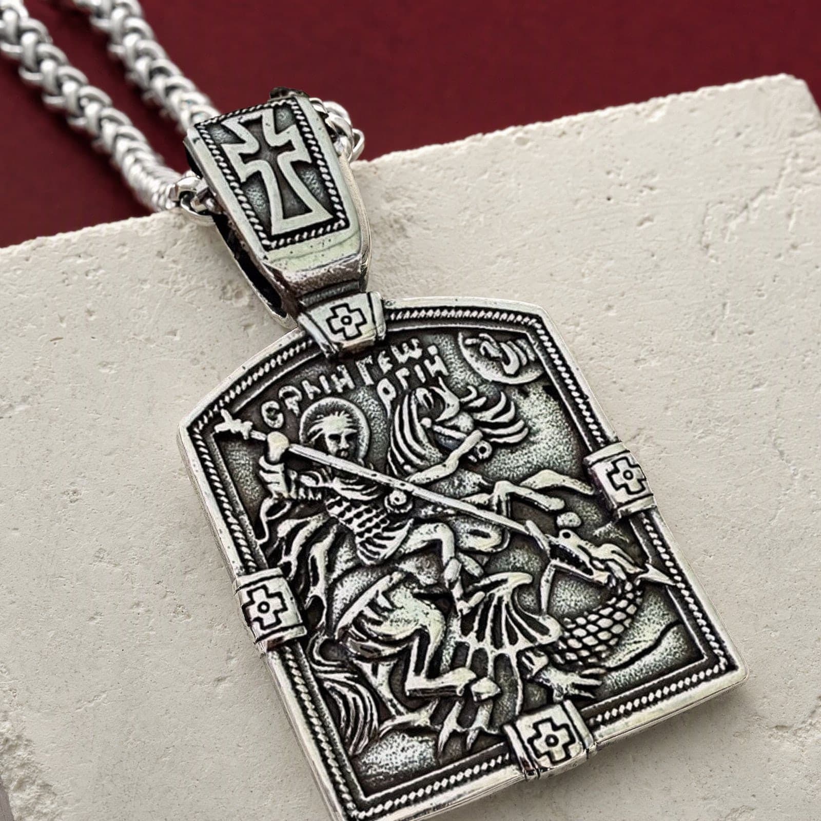 Close-up of the Orthodox St. George - Silver Color - 60cm Chain - Stainless Steel Medallion: the relief and the bail in raking light.