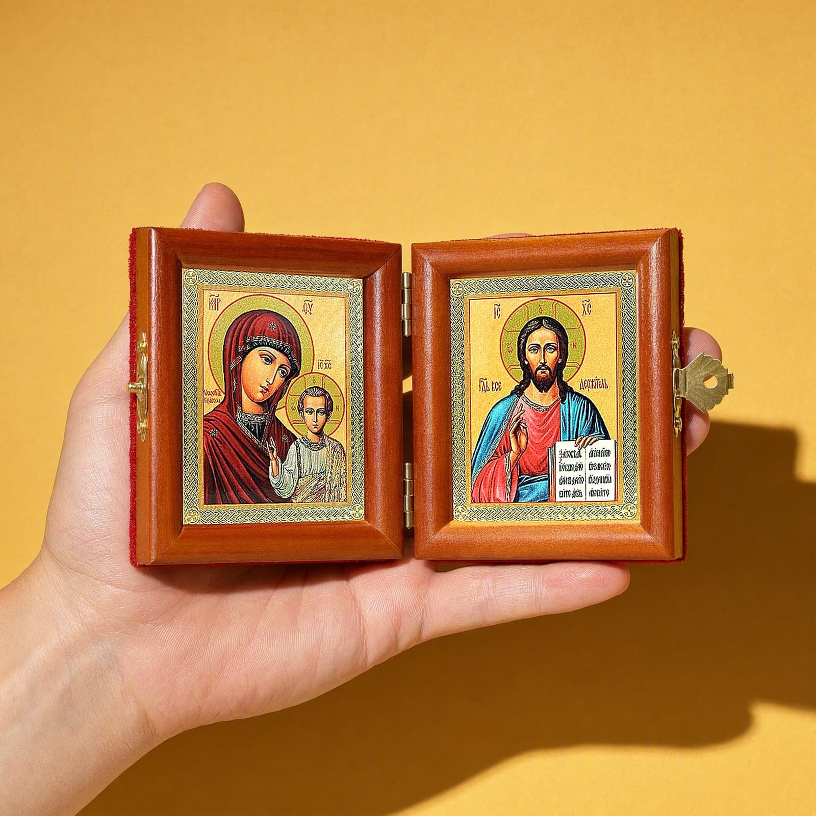 Christ Pantocrator & Our Lady of Kazan travel diptych held open in one hand to show its size: 16.5 cm wide open, about two palm widths.
