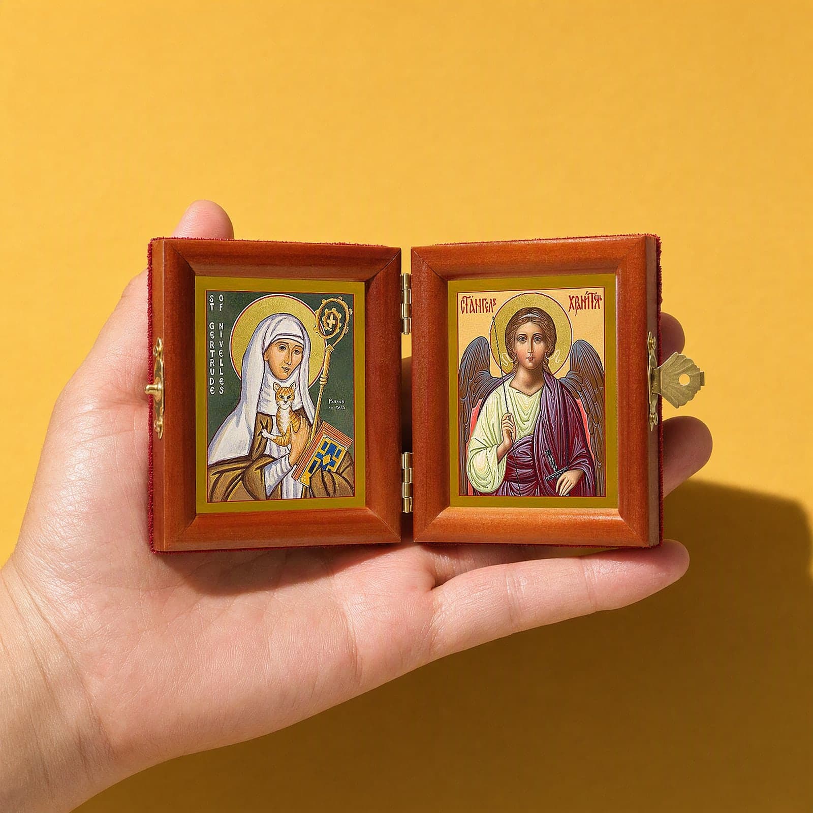 St Gertrude of Nivelles & Guardian Angel name diptych held open in one hand to show its size: 16.5 cm wide open, about two palm widths.