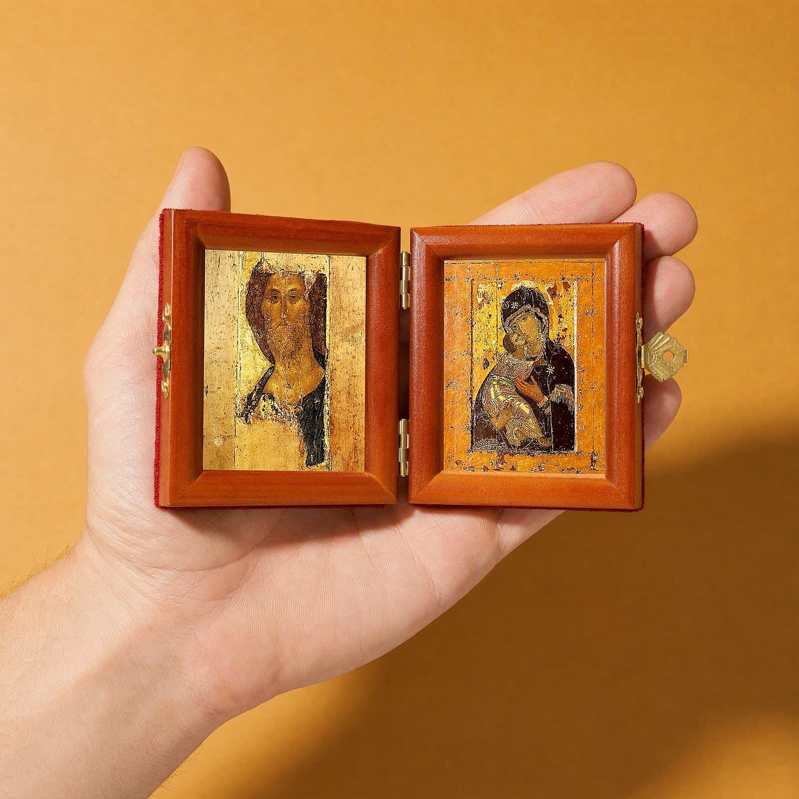 Christ (Zvenigorod Saviour) & Vladimir Mother of God travel diptych (Rublev era) held open in one hand to show its size: 16.5 cm wide open, about two palm widths.