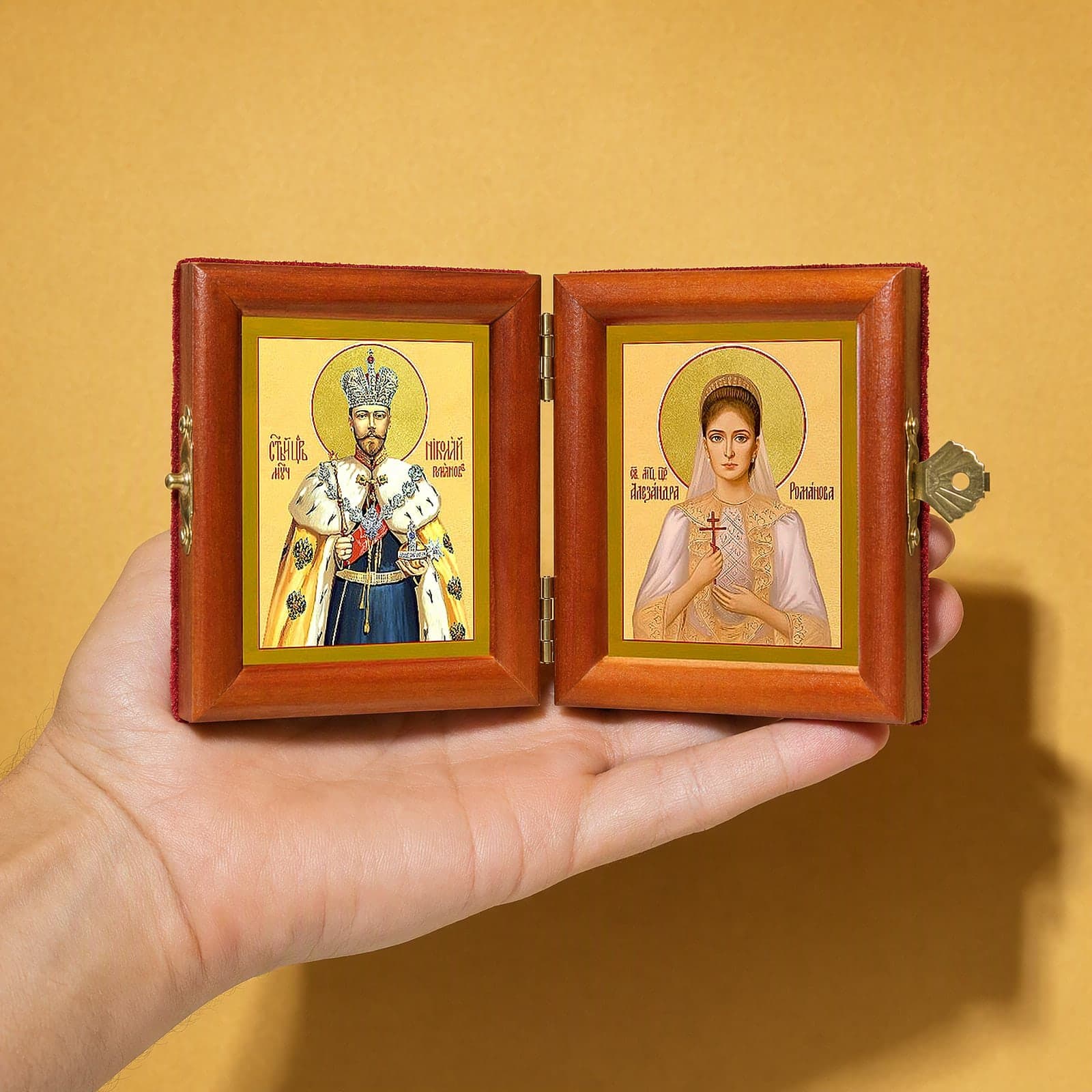 Sts Nicholas II & Alexandra (Royal Passion-Bearers) diptych held open in one hand to show its size: 16.5 cm wide open, about two palm widths.